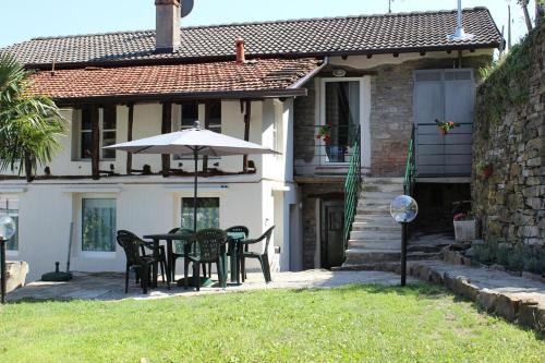 un patio con mesa y sombrilla en Rivacanze Apartments en Laglio