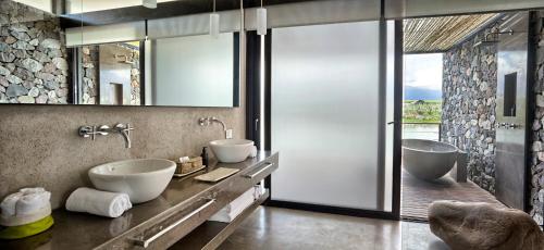a bathroom with two sinks and a large glass window at The Vines Resort & Spa in Los Sauces