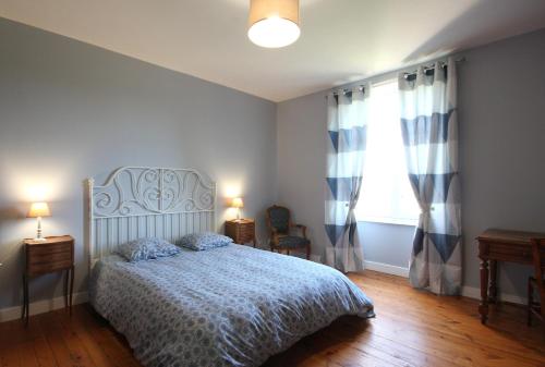 une chambre avec un lit avec une couverture bleue et une fenêtre dans l'établissement Gîte O'Haras, à Tierceville