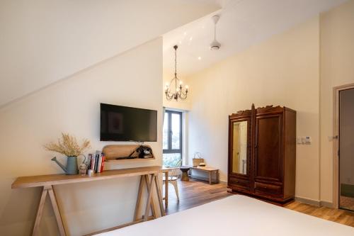 a room with a desk and a tv on a wall at La Em Boutique Villa in Da Lat