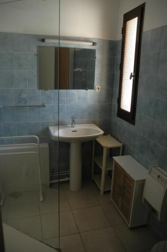 a bathroom with a sink and a glass shower at Maison individuelle au calme in Canet-en-Roussillon