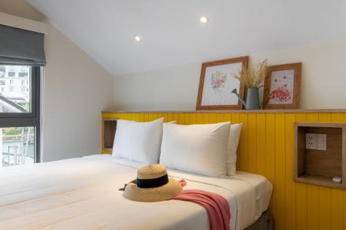 a hat sitting on top of a bed at La Em Boutique Villa in Da Lat