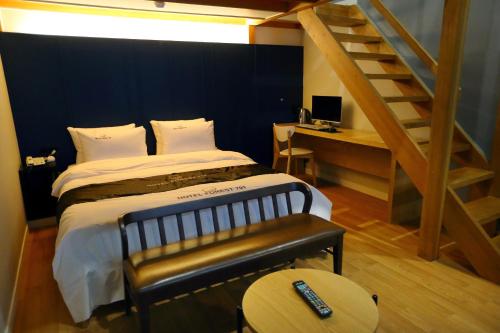 a bedroom with a bed with a staircase and a table at Forest 701 Hotel in Daegu