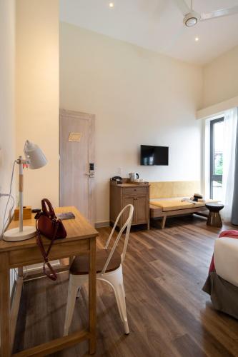 a living room with a desk and a bed at La Em Boutique Villa in Da Lat