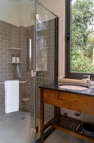 a bathroom with a glass shower with a sink at La Em Boutique Villa in Da Lat