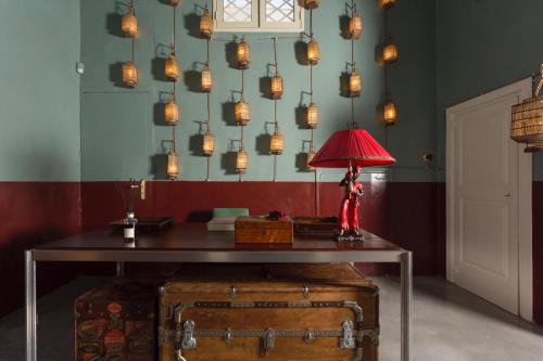 een kamer met een tafel met een rode lamp bovenop bij Palazzo Colombo in Gallipoli