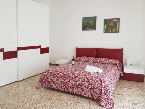 アルカモにあるCasa del Lauroのベッドルーム1室(赤いベッド1台、白いキャビネット2台付)