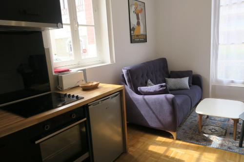 カブールにあるappartement dans villa cabourgeaiseの紫色のソファと椅子が備わるリビングルーム
