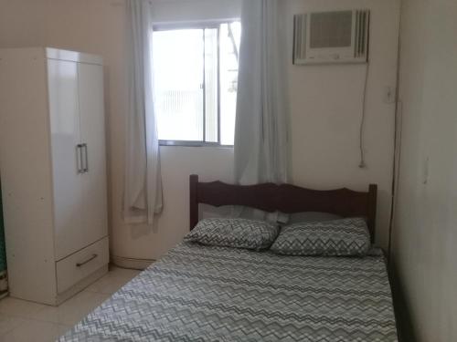 カボ・フリオにあるCantinho aconchegante 2 quartos, com ar condicionadoの窓付きのベッドルーム1室、ベッドサイドサイドサイドサイドサイドサイドサイドサイドサイドサイドサイドサイドサイドサイドサイドサイドサイドサイドサイドサイドサイドサイドサイドサイドサイドサイドサイドサイドサイドサイドサイドサイドサイドサイドサイドサイドサイドサイドサイドサイドサイドサイドサイドサイドサイドサイドサイドサイドサイドサイドサイドサイドベッド