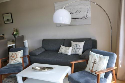 a living room with a couch and chairs and a table at Schicke FeWo 150m vom Strand kostenlos WLAN großes Schwimmbad Sauna in Cuxhaven