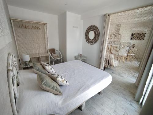 a white bedroom with a bed and a window at Apartamento Laura in Peñíscola