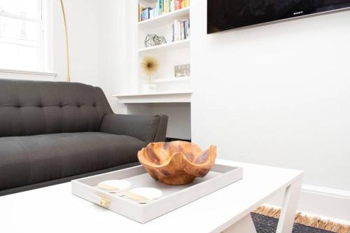 a living room with a white coffee table with a wooden bowl on it at * Midcentury Modern Getaway * Prime Location * in Annapolis