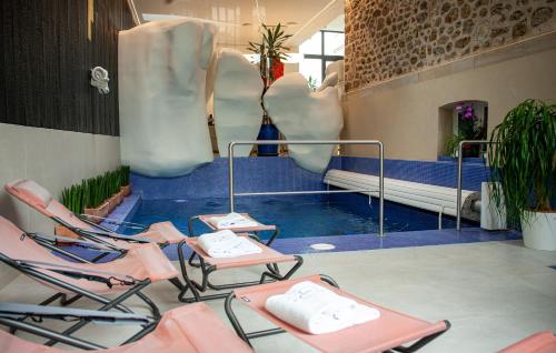 a room filled with lots of chairs and a pool at Manoir Henri Giraud & Spa in Épernay