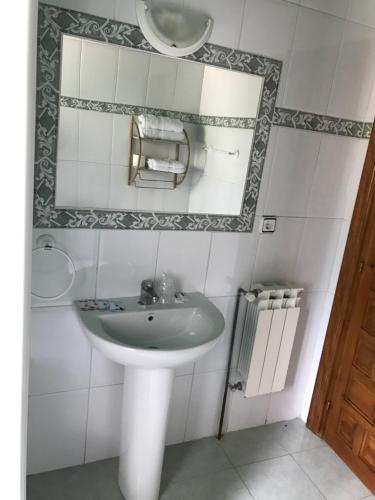 a white bathroom with a sink and a mirror at LA CASONA DE PALMIRA in Caín