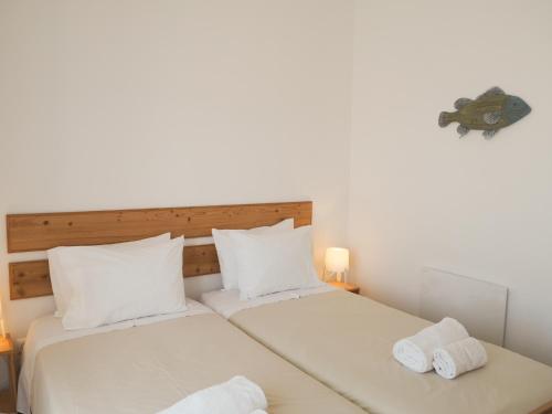 two beds in a room with two towels at Casa Boa Onda in Sagres
