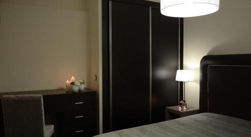 a bedroom with a black cabinet and a bed with candles at Vila Hotel By VimaHotels in Guimarães