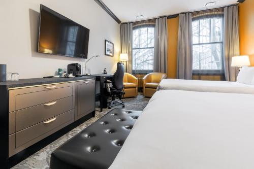 a hotel room with a bed and a desk at Hotel Clarendon in Quebec City