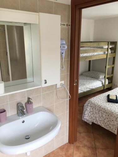 łazienka z umywalką i 2 łóżkami piętrowymi w obiekcie Baita Dal Vikingo w mieście Sorico