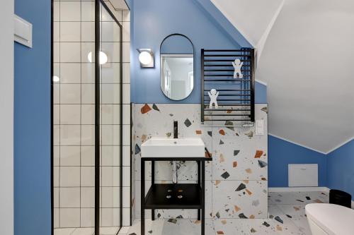 a bathroom with a sink and a blue wall at Apartament Haffnera 30 in Sopot