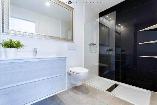 La salle de bains est pourvue de toilettes et d'une douche en verre. dans l'établissement Apartamento en la planta baja "Playa Elisa", à Pilar de la Horadada