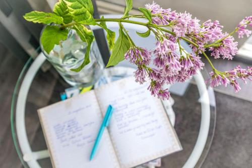 a book and a vase with flowers on a table at B&B Carpe Diem in Hulst