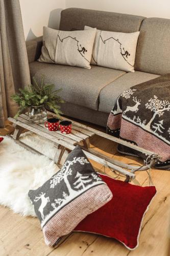 a living room with a couch and pillows on the floor at Apartments and Rooms Kaja in Kranjska Gora