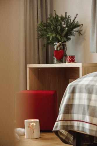 a bedroom with a bed with a red chair and a plant at Apartments and Rooms Kaja in Kranjska Gora