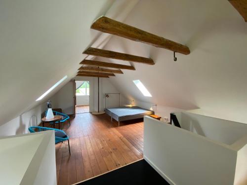 an attic room with a bed and a couch at Stenhuset i Pilbrodalen in Skanderborg