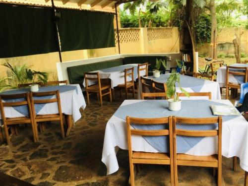 un groupe de tables et de chaises dans un restaurant dans l'établissement Mama Pierina Restaurant and Annex, à Morogoro