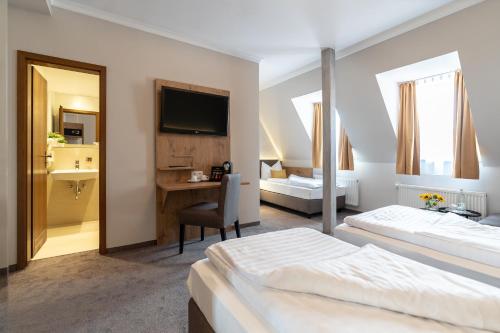 a hotel room with two beds and a desk at Hotel & Restaurant Ritter Jörg in Sommerhausen