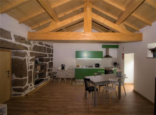 uma cozinha e sala de jantar com uma parede de pedra em Beirais do Alvão em Vila Real