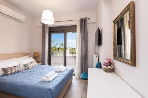 a bedroom with a blue bed and a balcony at Peris Villa in Kato Daratso