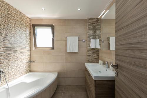a bathroom with a tub and a sink at Peris Villa in Kato Daratso