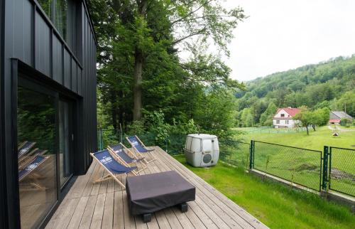eine Terrasse mit Stühlen und eine Mülltonne auf einem Haus in der Unterkunft Minimal House in Szczyrk