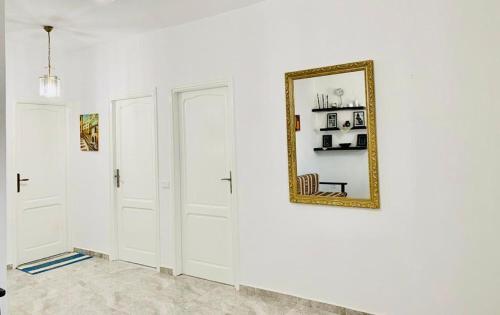 Pokój z białymi ścianami i lustrem na ścianie w obiekcie Un emplacement exceptionnel w mieście Tunis
