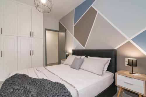 a bedroom with a bed and a geometric wall at Valentine's Modern Apartment in Zakynthos Town