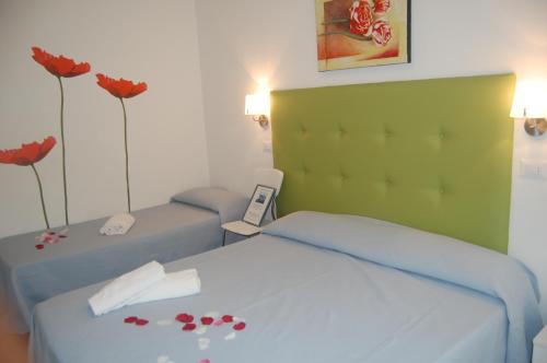 a bedroom with two beds with red flowers on it at Hotel Irene in Lignano Sabbiadoro