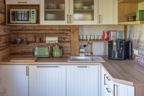 a kitchen with white cabinets and a counter top at Hundi Holiday Home Main House in Hiiumaa