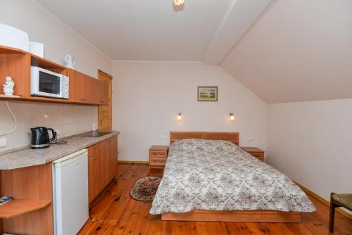 um pequeno quarto com uma cama e uma cozinha em Poilsis prie Dineikos parko em Druskininkai
