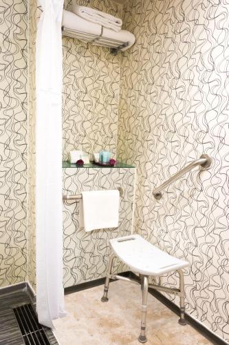 a bathroom with a chair and a towel rack at Crowne Plaza Toluca - Lancaster by IHG in Toluca