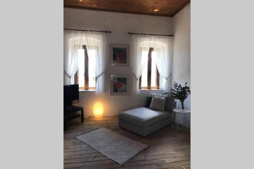 a living room with a couch and two windows at Traditional Stone House in Eastern Mani in Flomokhórion