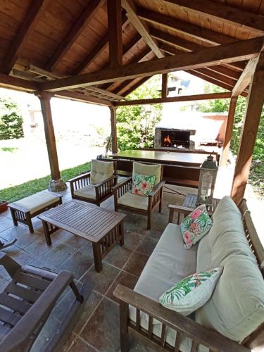 un patio con sofá, mesas y piano en Casa Begoña, en Igüeña