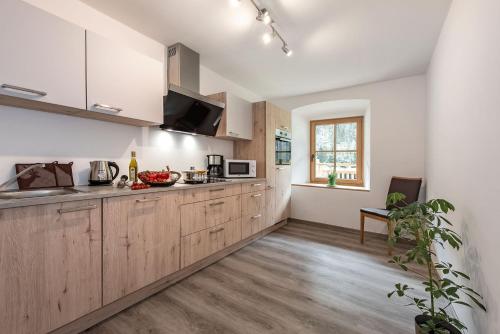 a kitchen with white walls and wooden cabinets at Blasighof in Quinzo