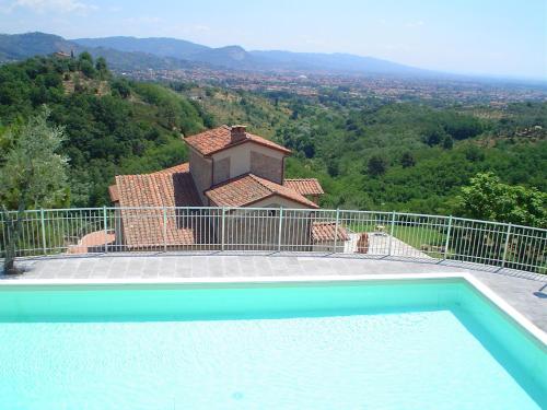 a swimming pool in front of a house at B&B Hotel La Piana in Borgo a Buggiano