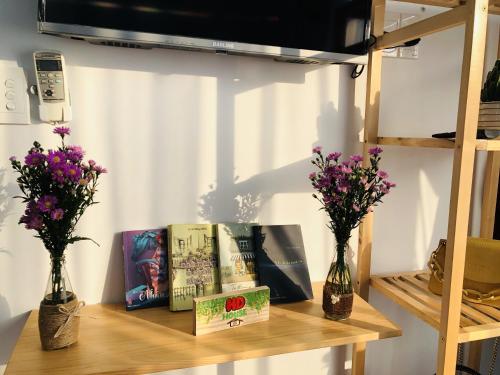 uma mesa com alguns livros e flores em HD House Homestay Vũng Tàu em Vung Tau