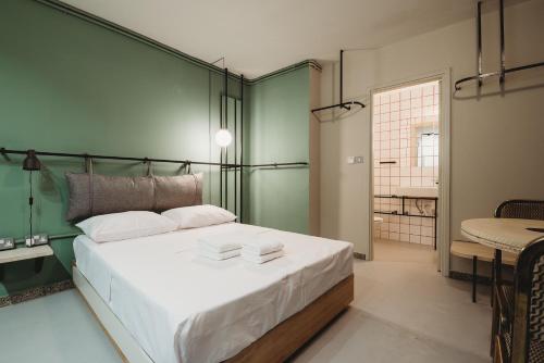 um quarto com uma cama grande e uma parede verde em eins rooms - city center em Limassol