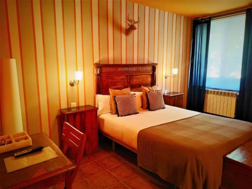 a hotel room with a bed and a table and a desk at Hotel Rural Curia in El Castellar
