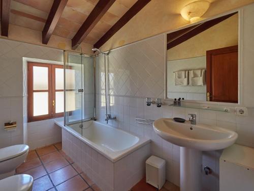 a bathroom with a tub and a sink and a toilet at Sa Barcella in Sineu