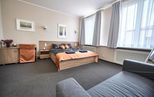 a bedroom with a bed and a couch at Stara Cynkownia in Czechowice-Dziedzice