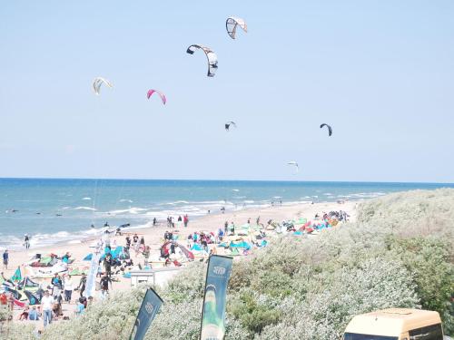 a group of people on a beach with people flying kites at Bungalow in Neubukow mit Terrasse und Garten in Neubukow